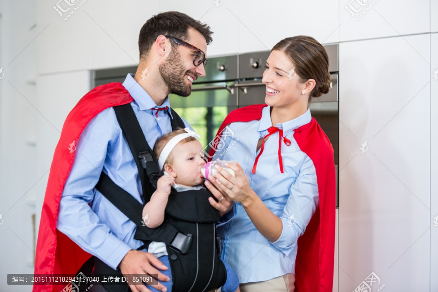 穿着英雄服装给女儿喂奶的夫妇