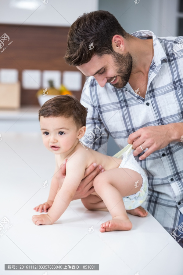 在检查婴儿尿布的父亲