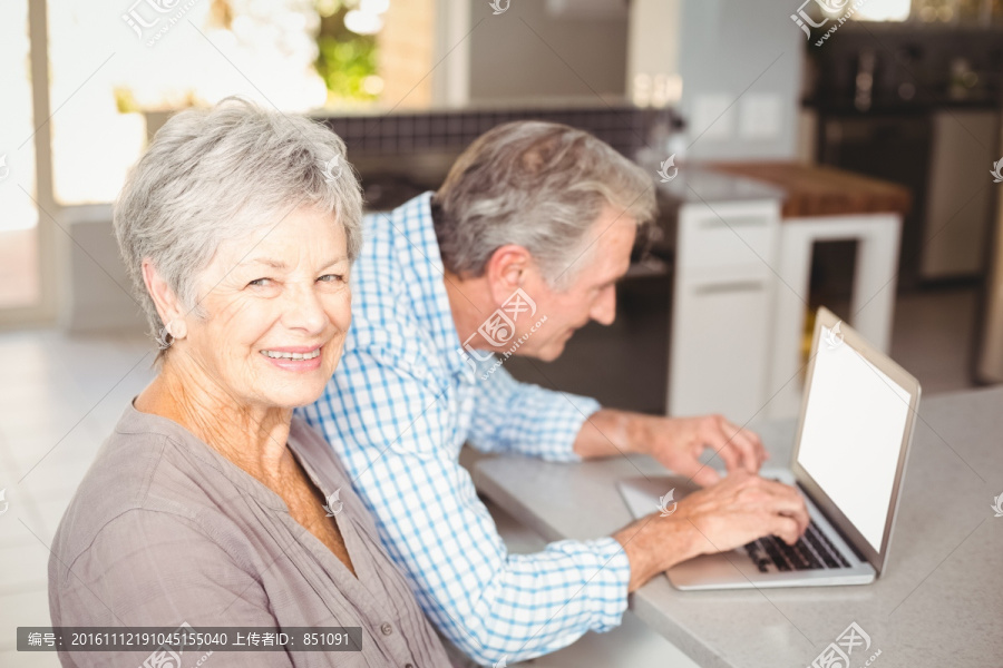 在使用笔记本电脑的一对老夫妇