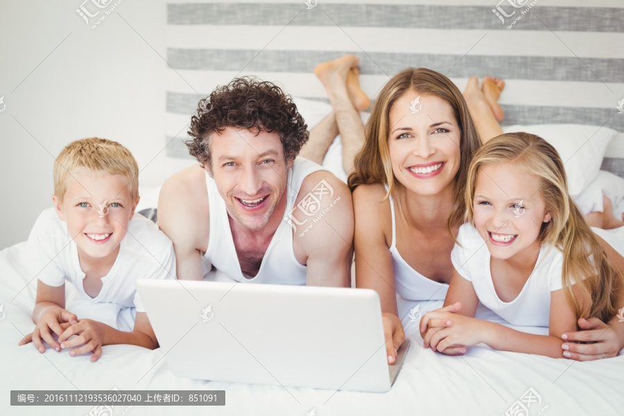 趴在床上使用笔记本电脑的家人
