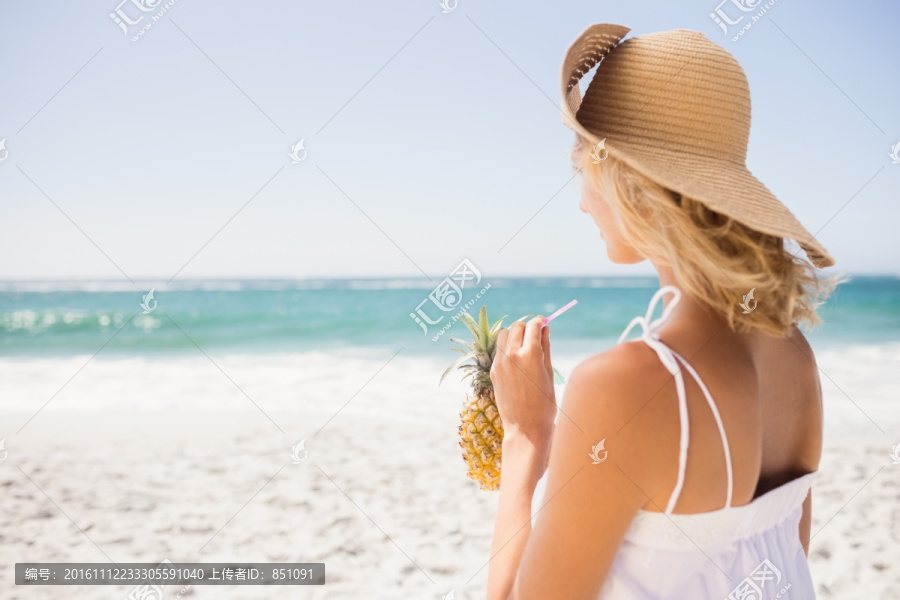 在海边喝鸡尾酒的女人