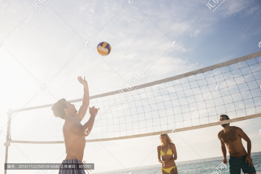 在沙滩上打排球的年轻人