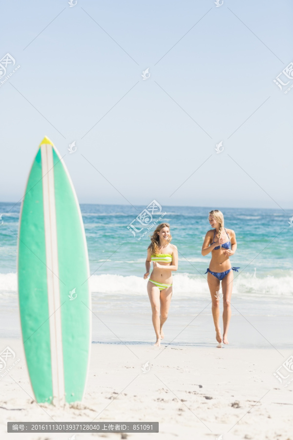 在海边奔跑的两个女人