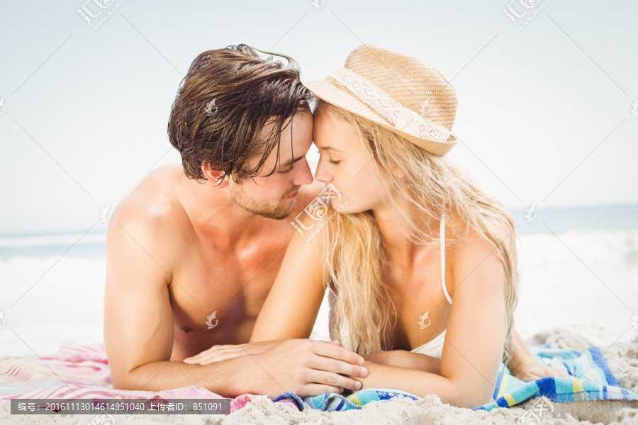 趴在海滩上的年轻夫妇