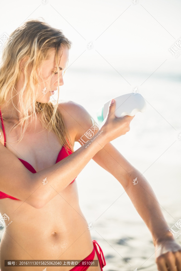 女人在海滩上涂防晒油