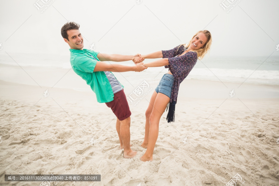 手拉手站在沙滩上的情侣
