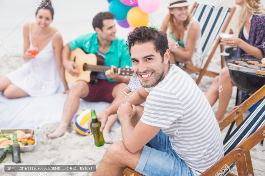坐在沙滩上喝酒听吉他的朋友们