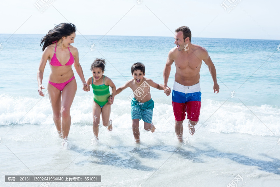 在海边牵着手奔跑的家人