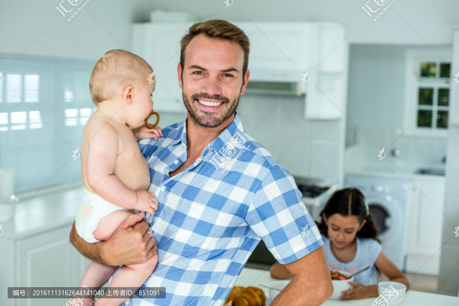 抱着儿子在厨房里的父亲