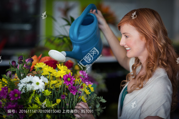 在给花卉浇水的女人