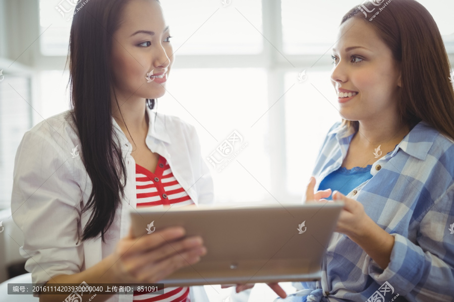 看着平板电脑交谈的女人