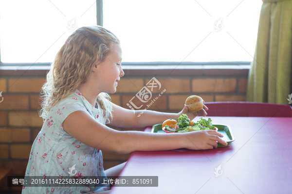 在食堂吃饭的小学女生