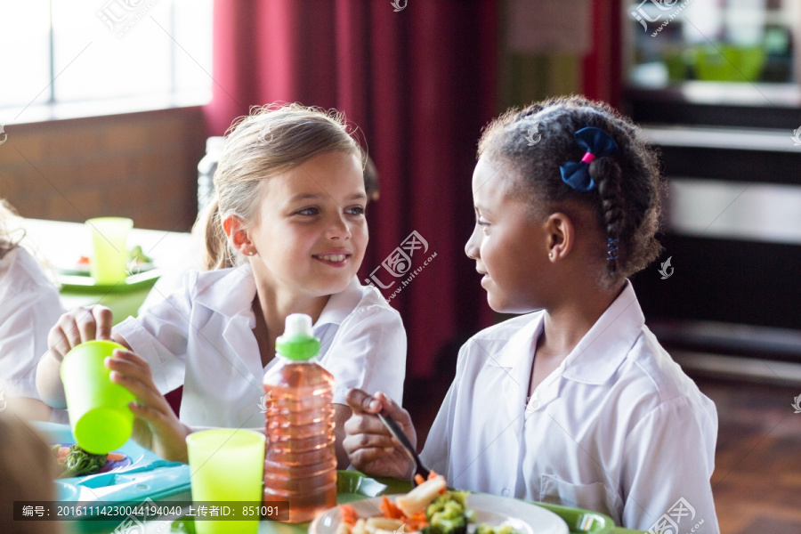 可爱的女孩在学校食堂吃食物