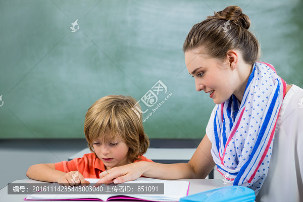 在教室里指导学生学习的女老师