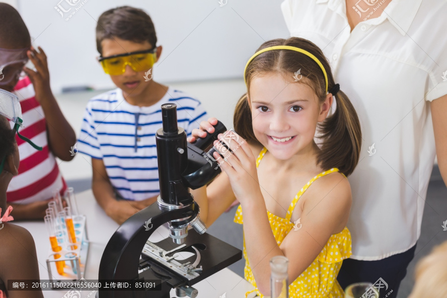 在实验室使用显微镜的小学生