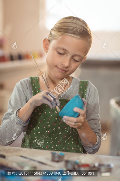 在陶器碗上绘画的女孩