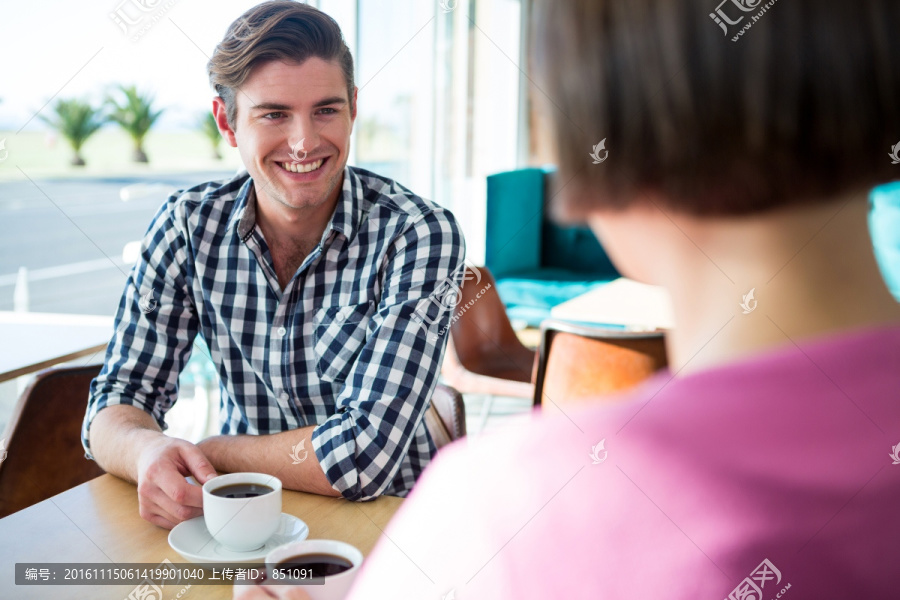 在咖啡馆里聊天的一对年轻夫妇
