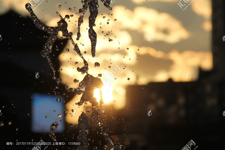 太阳光夕阳下的喷泉水珠背景