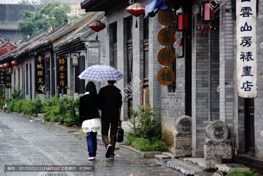 雨中古街打伞的一对恋人