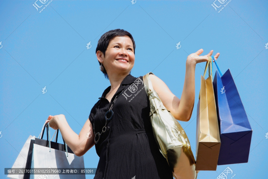 成熟的女人拎着购物袋