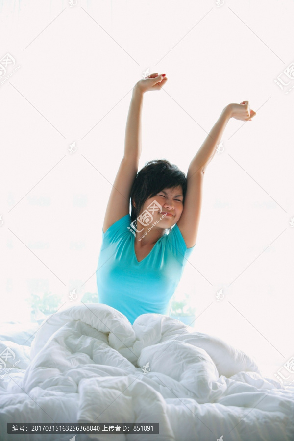 妇女在床上伸展