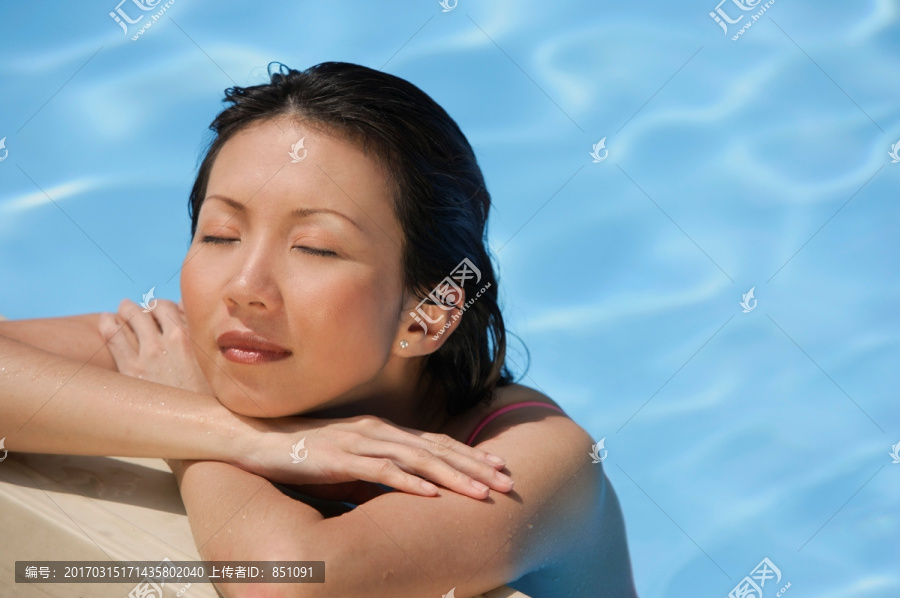 女人倚在游泳池边