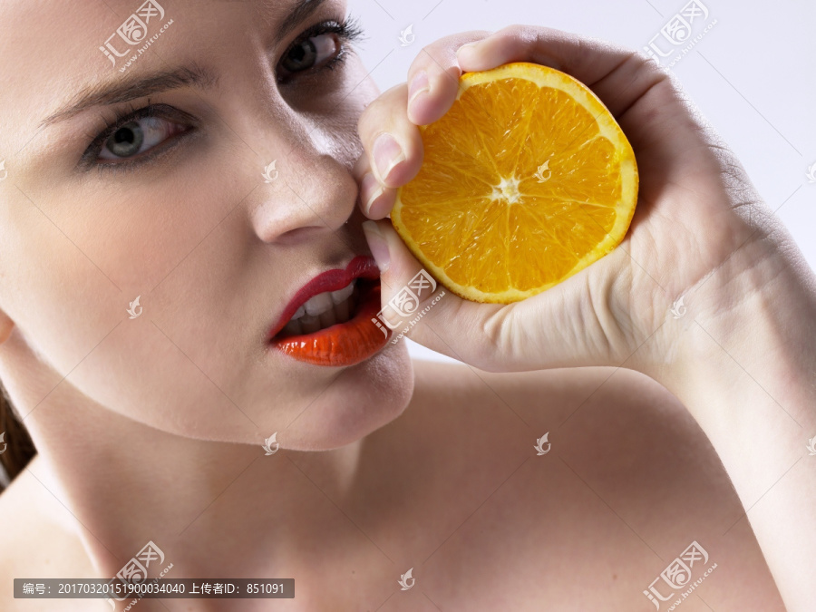 拿着一个橙子的女人