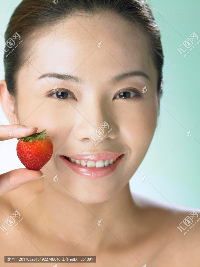 拿着一个草莓的女人