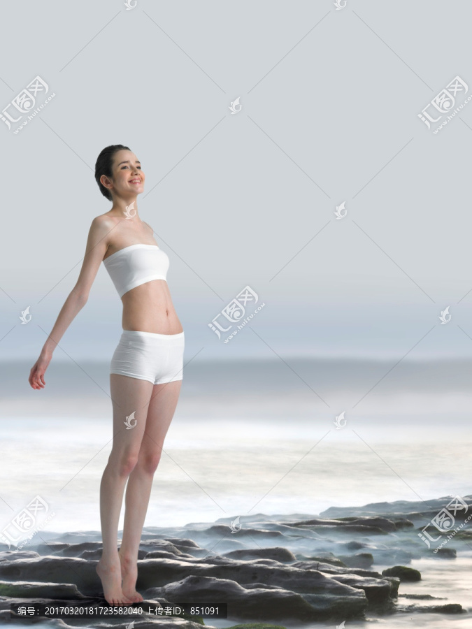 站在沙滩上张开手臂的女人