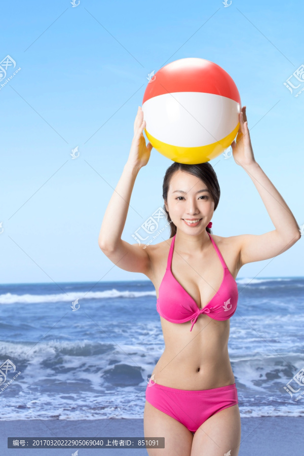 穿着比基尼拿着沙滩球的女人