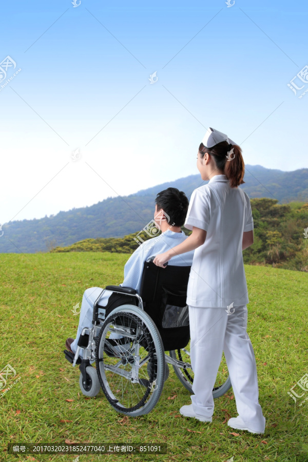 护士推着坐轮椅的病人看风景