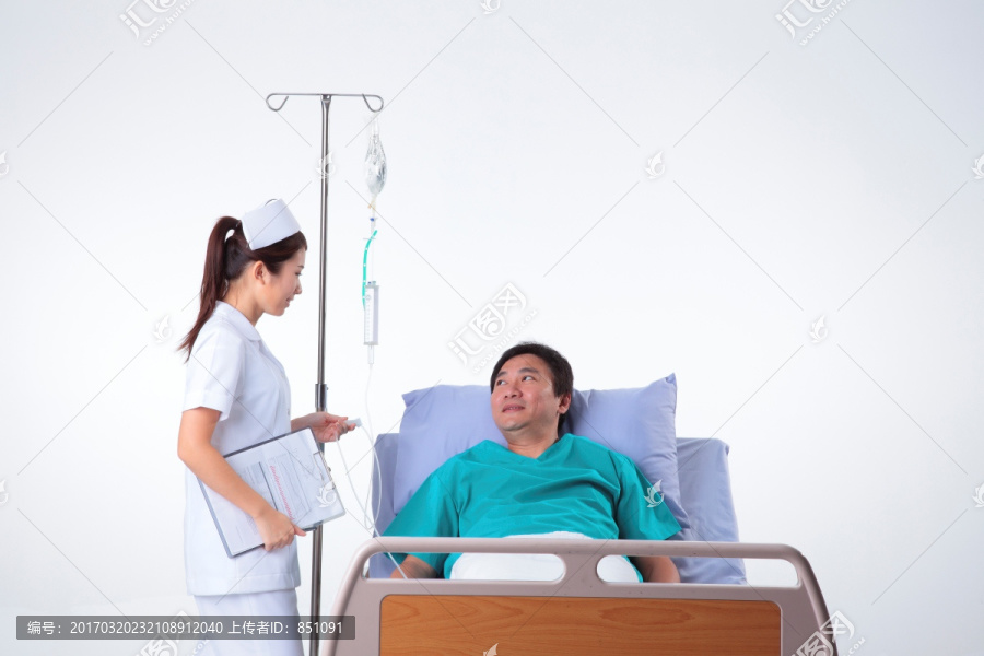 护士微笑着看着挂点滴的病人