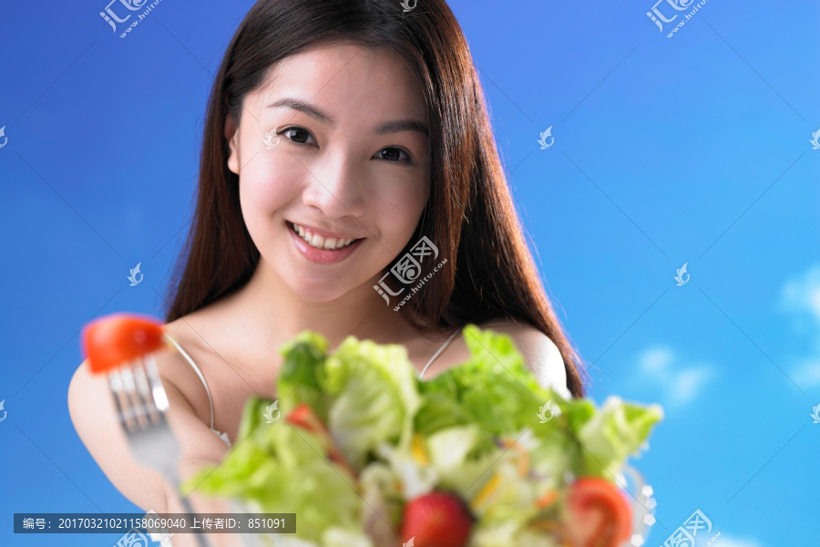 微笑着拿着蔬菜的女人