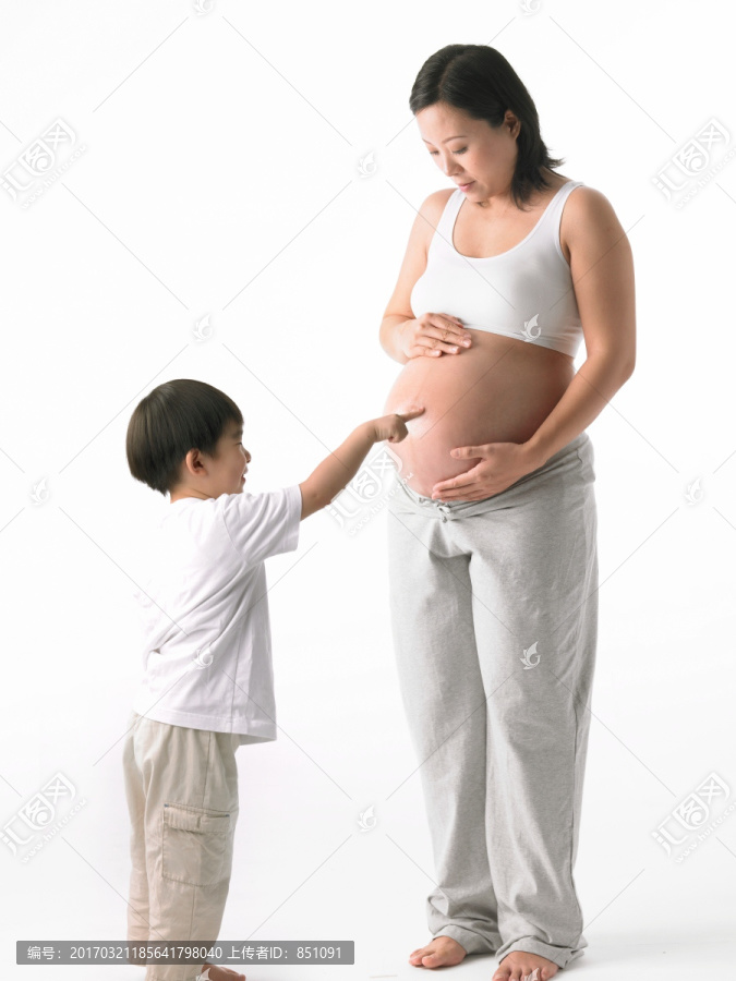 指着孕妇妈妈肚子的小男孩