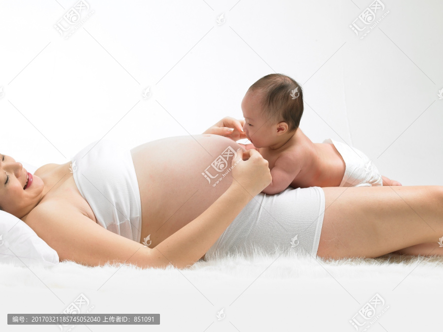 趴在孕妇妈妈肚子上的婴儿
