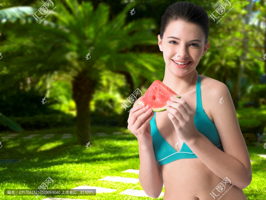 在吃一块西瓜的年轻女人
