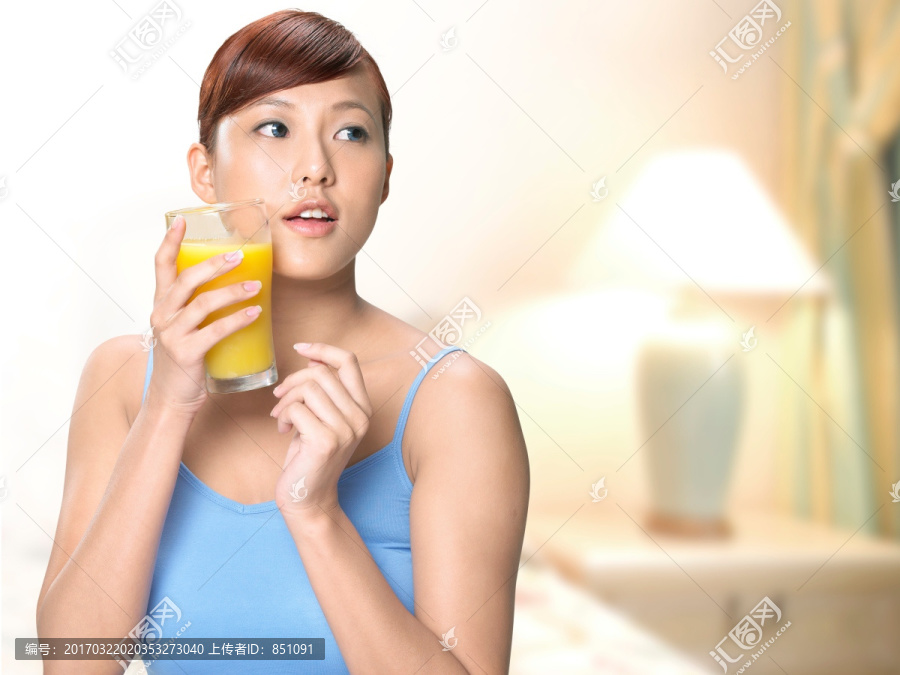 拿着一杯橙汁的女人