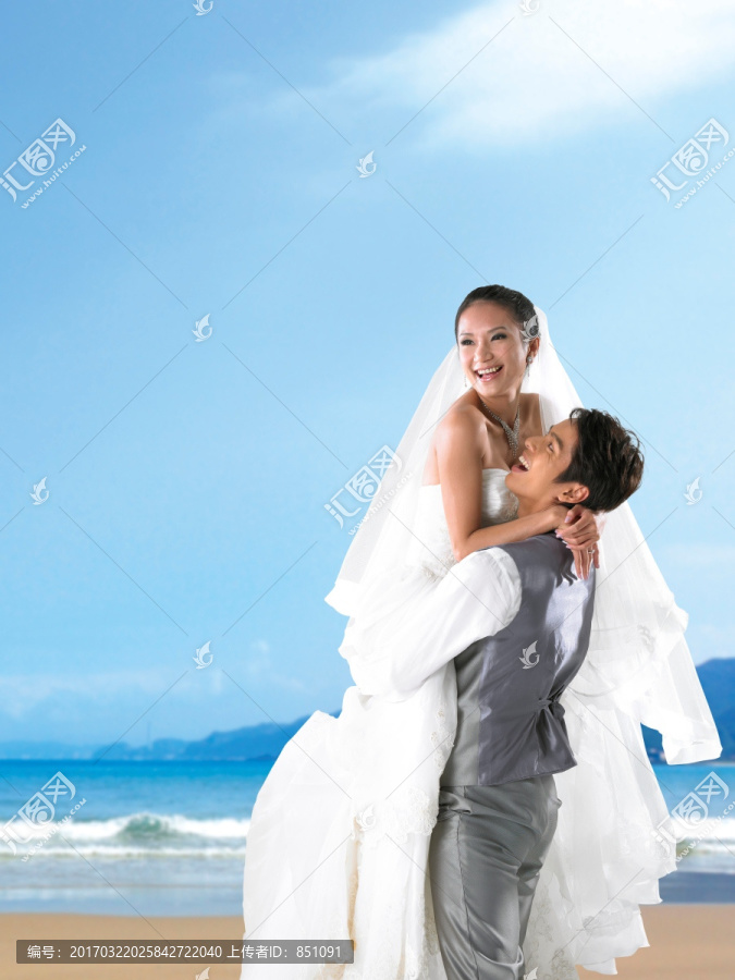 在海边抱起新娘的新郎