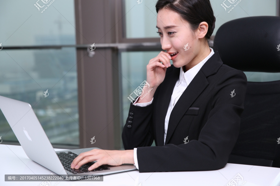 开心的女人看着笔记本电脑