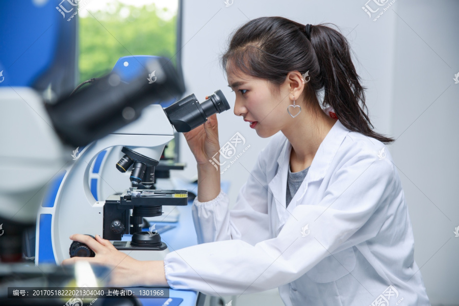 在使用显微镜的女大学生