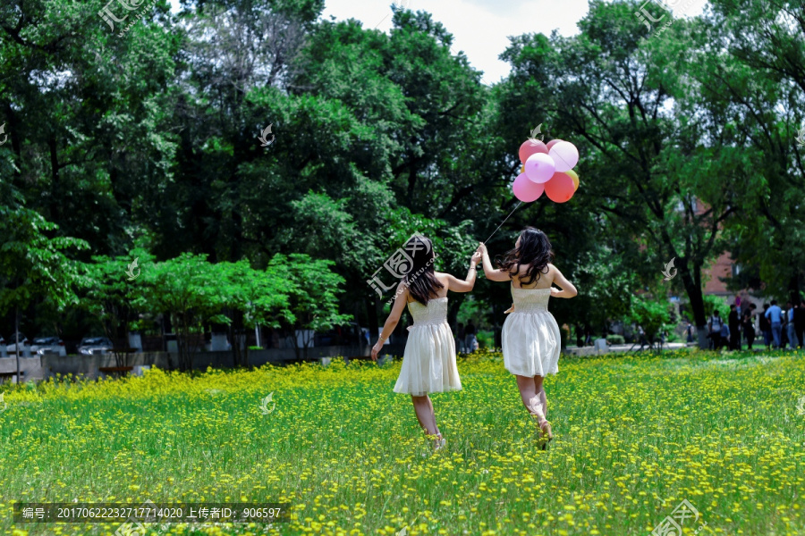 绿草地里手拿气球的青春女孩