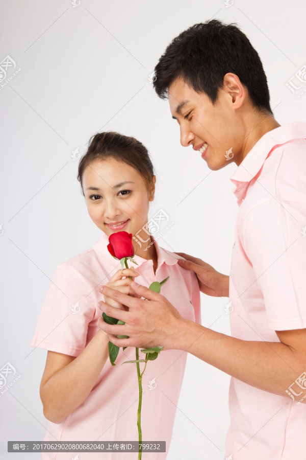 年轻情侣拿着玫瑰花