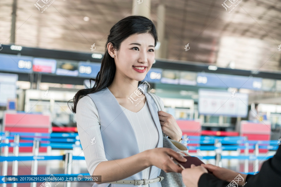 年轻商务女士在机场出示护照