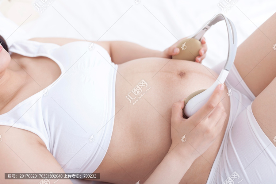 孕妇拿耳机放在肚子上胎教