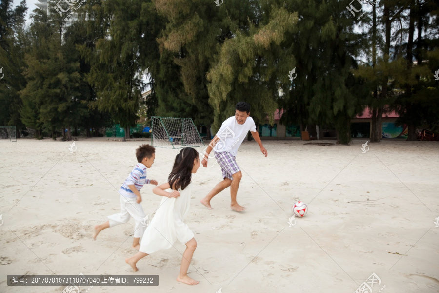 中年人和小女孩,小男孩在海边踢足球