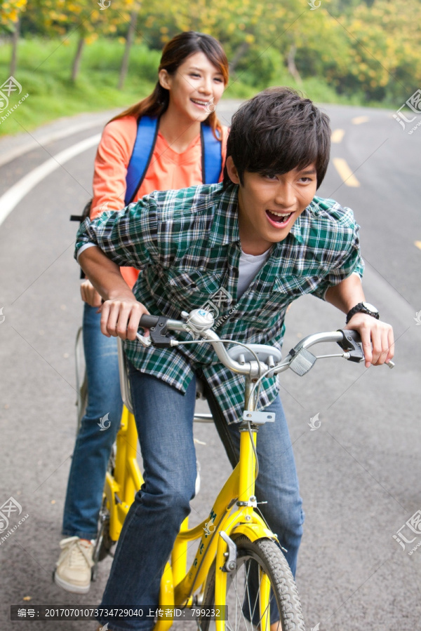 年轻大学生情侣在校园里骑车