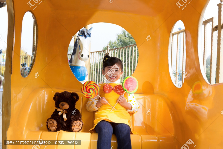 拿着棒棒糖的小女孩坐在童话马车里