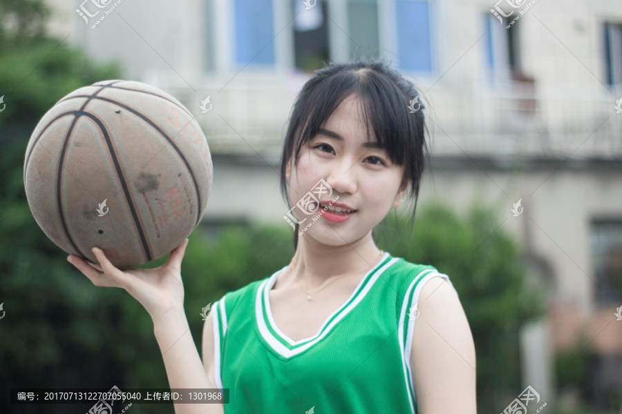 单手拿着篮球的女大学生