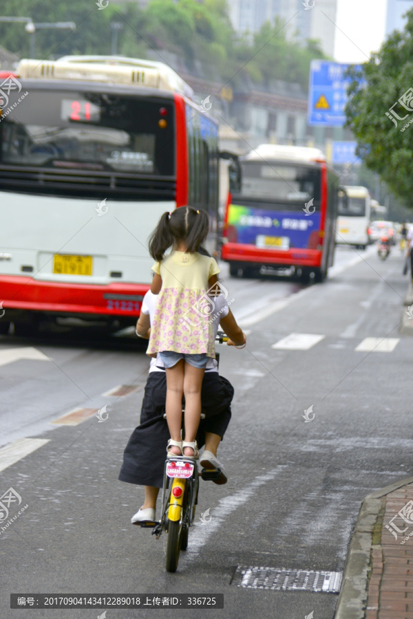 乘妈妈自行车的小女孩