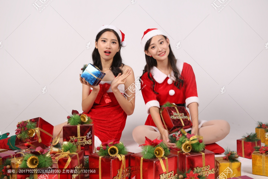 戴着圣诞帽坐着微笑的两女人